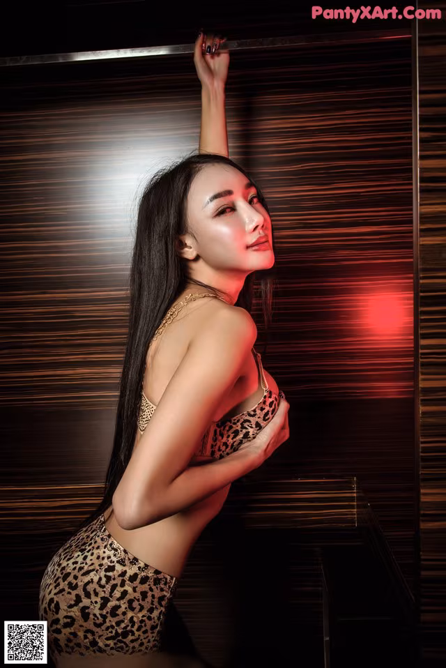 A woman in a leopard print lingerie posing for a picture.