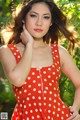 A woman in a red and white polka dot dress posing for a picture.