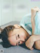 A woman laying on the floor with her head on her hands.