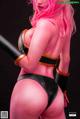 A woman with pink hair holding a baseball bat.