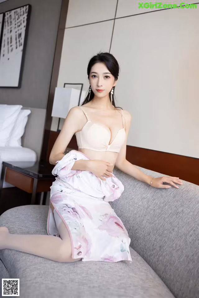 A woman sitting on top of a couch in a room.