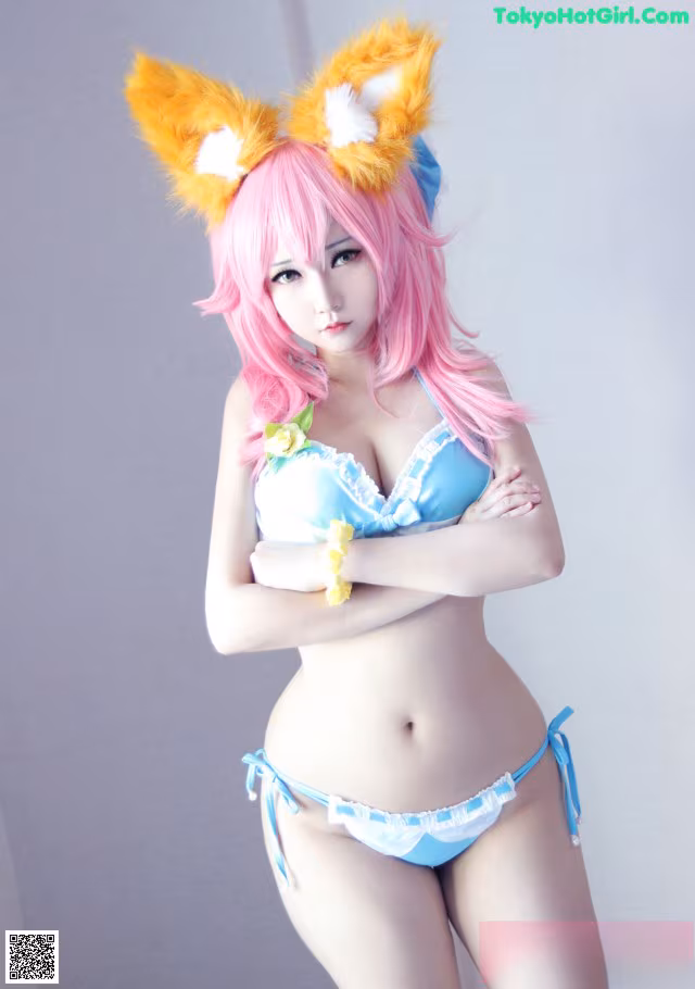 A woman in a blue bikini with pink hair and fox ears.