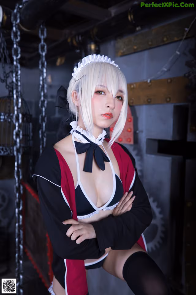 A woman in a maid outfit posing for a picture.
