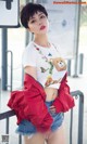 A woman in a white shirt and a red jacket posing for a picture.