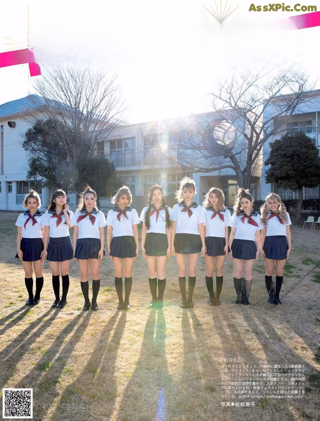 A group of girls in school uniforms posing for a picture.