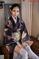 A woman in a kimono sitting on a couch.