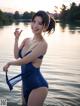 A woman in a blue bathing suit standing in the water.