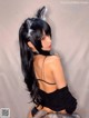 A woman with long black hair wearing a cat ears headband.