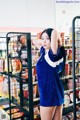 A woman standing in front of a shelf of food.