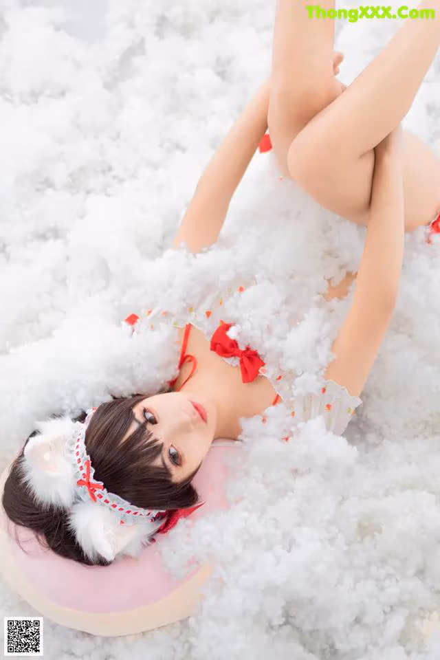 A woman in a red and white lingerie laying in the snow.