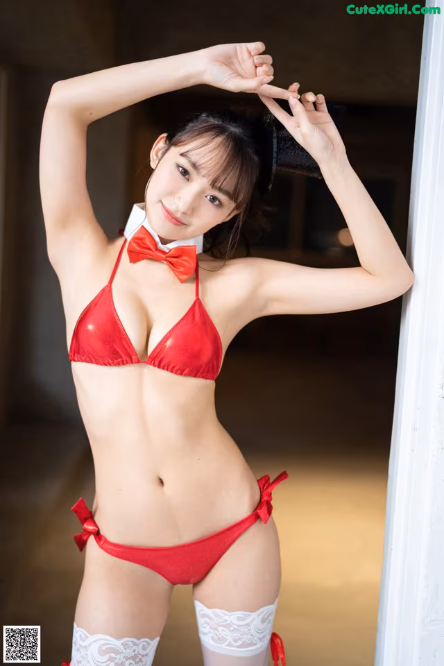 A woman in a red bikini and white stockings posing for a picture.